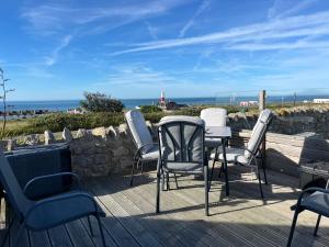 a group of chairs and tables on a deck with the ocean at The Old Boathouse in Southwell