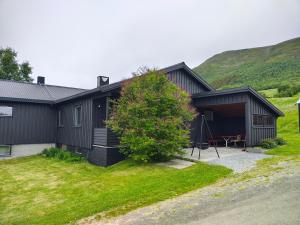 a black house with a hill in the background at Three bedroom home with an amazing mountain view! in Oppdal