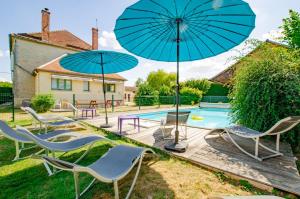 a group of chairs and umbrellas next to a pool at Aube au gite in Trannes