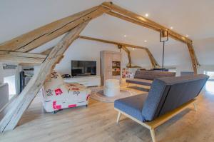 a living room with two couches and a tv at Aube au gite in Trannes