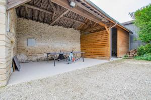 a patio with a table in a brick building at Aube au gite in Trannes