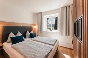 a bedroom with two beds with blue pillows at Echo am See in Gmunden