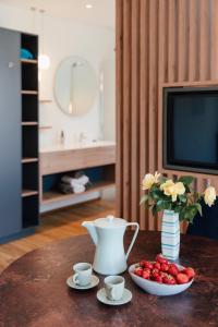 a table with a tea pot and a bowl of strawberries at Echo am See in Gmunden