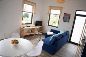 a living room with a blue couch and a table at Casa da Vila Apartments in Arco da Calheta
