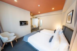 a bedroom with a white bed and a chair at King Tamar Hotel By Luxuria Hotels in Tbilisi City