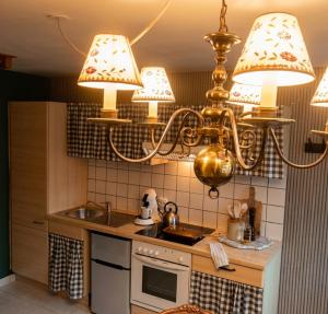 a kitchen with a chandelier above a kitchen counter at Escapade en Alsace - gîte de charme pour deux à Bergheim in Bergheim