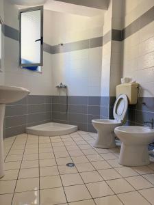 a bathroom with two toilets and a sink at AS Orikum 1 in Orikum +22 photos