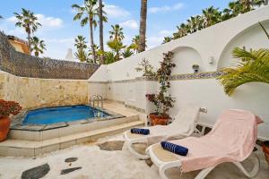 a house with a swimming pool and two chairs at Private Pool And Ocean Views in Chayofa