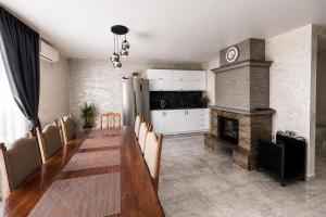 a dining room with a long table and a fireplace at Вілла Смерекова хата in Kelechin