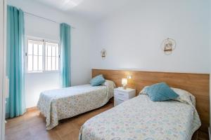 a bedroom with two beds and a window at Casa Rural Rafael in La Lantejuela +35 photos