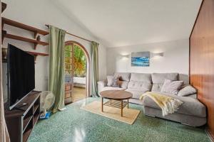 a living room with a couch and a tv at Private Pool And Ocean Views in Chayofa