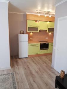 a kitchen with green cabinets and a white refrigerator at The Loka in Riga