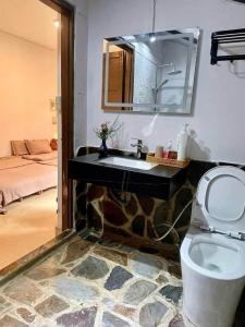 a bathroom with a sink and a toilet with a mirror at SugarHouse in Da Thanh