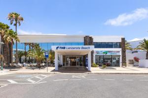 a store front with palm trees in front of a street at THB Lanzarote Beach in Costa Teguise +57 photos