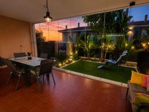 a dining room with a table and a view of a garden at Bungalow with Pool & BBQ - Carabassi Beach 10' in Gran Alacant