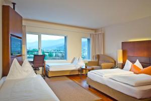 a hotel room with two beds and a couch at Hotel Penz West in Innsbruck +37 photos