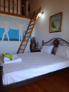 a bedroom with a bed with a ladder on the wall at Zacharoula Rooms in Manganítis
