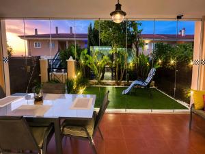 a dining room with a view of a garden at Bungalow with Pool & BBQ - Carabassi Beach 10' in Gran Alacant