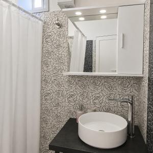a bathroom with a white sink and a mirror at Meltemi Studios Polychrono in Polychrono