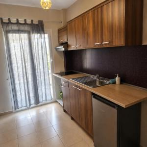 a kitchen with wooden cabinets and a sink and a window at Meltemi Studios Polychrono in Polychrono +9 photos