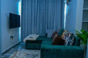 a living room with a green couch and a window at Kiesth Whiskaway in Kiambu
