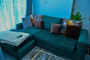 a green couch with pillows in a living room at Kiesth Whiskaway in Kiambu +2 photos
