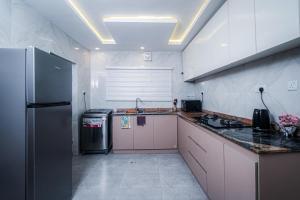 a kitchen with a refrigerator and a counter top at 2 bedroom Atrium apartment in Gwarinpa