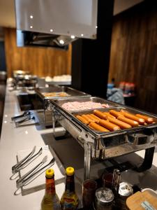 a bunch of hot dogs on a grill in a kitchen at Avana Laem Chabang Boutique Hotel in Ban Laem Chabang