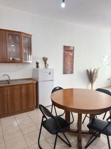 a kitchen with a wooden table and chairs and a table at AS Orikum 1 in Orikum