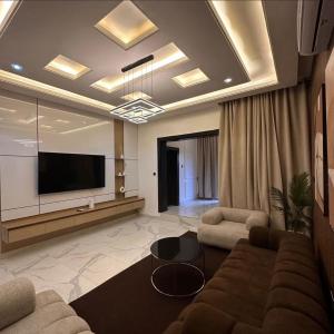 a living room with a couch and a flat screen tv at 2 bedroom Atrium apartment in Gwarinpa