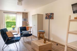 a living room with chairs and a table at ParelDuyn in Oostkapelle