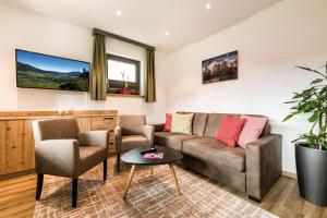 a living room with a couch and two chairs and a table at Lechappart in Hofen
