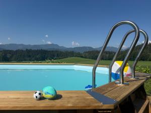 a pool with a wooden deck and a soccer ball at Einfach bei uns in Fresach