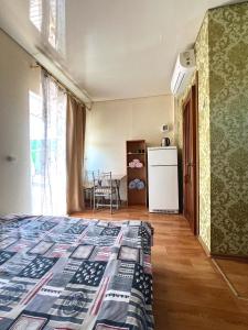 a room with a bed and a kitchen with a refrigerator at Hotel Yuzhanka in Sanzhiyka