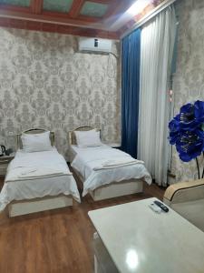 a hospital room with two beds and a table at Sheykh in Andizhan