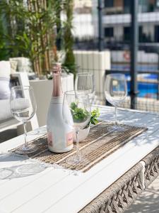 a bottle of wine and three wine glasses on a table at Xava Dreams Aire in Villacosta