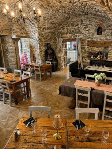 a restaurant with tables and chairs and a fireplace at Les Chambres Cast'elles in Malves