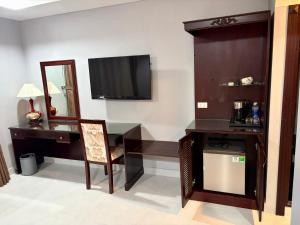 a room with a desk and a television on a wall at Hotel Thiên Hồng in Phú Quốc