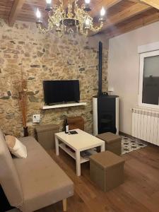 a living room with a table and a stone wall at Las Riendas II La Casina in Muñeca