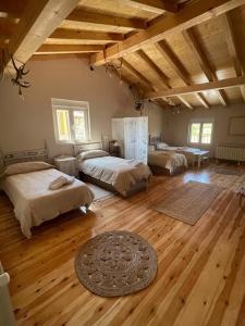 a large room with three beds and a wooden floor at Las Riendas II La Casina in Muñeca