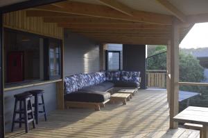 a screened porch with a couch on a patio at Seals Tides - sleeps 12 in Cape St Francis