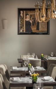a dining room with tables and a picture of a woman at Zamek Topacz in Wrocław