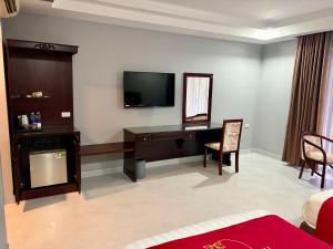 a living room with a desk and a television at Hotel Thiên Hồng in Phú Quốc