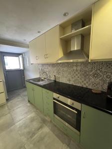 a kitchen with green cabinets and a black counter top at Tiny Diamond in Plomari