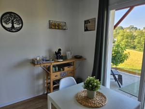 a room with a desk and a table and a window at Chambre avec vue in Villefranque