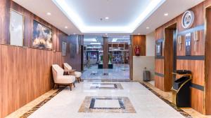 a lobby with wood paneling and a hallway with chairs at الحياة للشقق الفندقية in Jeddah