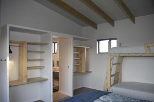 a bedroom with a bunk bed and a bunk room with shelves at Seals Tides - sleeps 12 in Cape St Francis