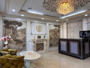a living room with a fireplace and a chandelier at Marvarid Hotel in Ghijduwon