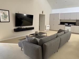 a living room with a couch and a flat screen tv at Sillage in Machiel