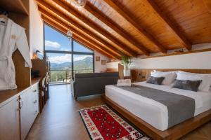 a bedroom with a large bed and a large window at Vila Harmoni Roshnik in Roshnik